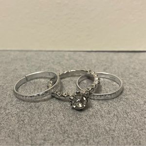 Three silver rings, one set with a stone, the two without a stone are adjustable